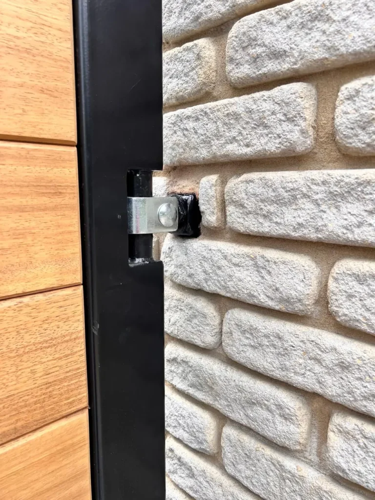 Automated timber driveway gates outside a private house on a block-paved drive