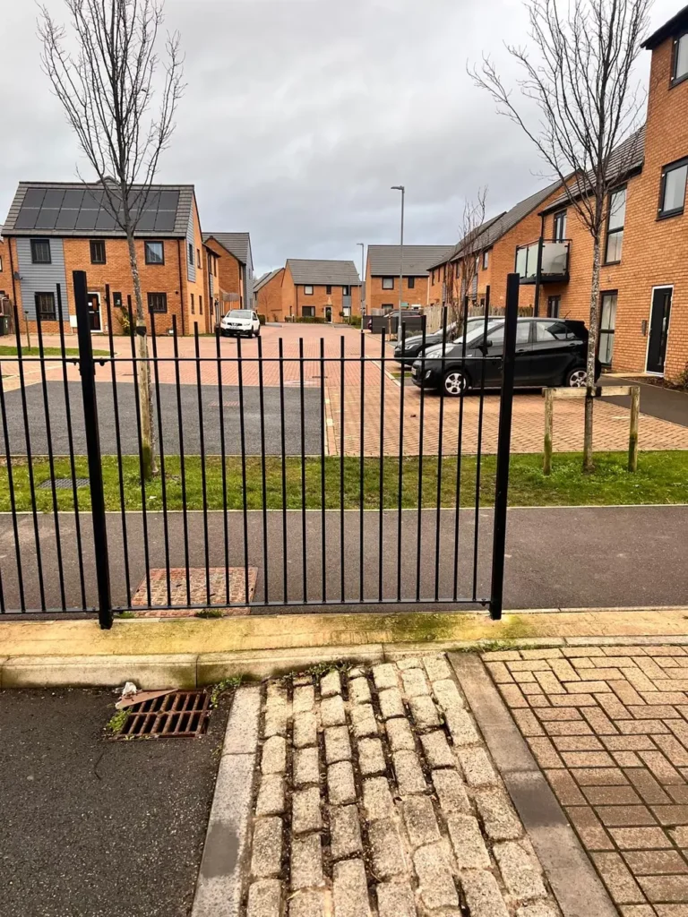 Black metal estate gates at a housing development entrance