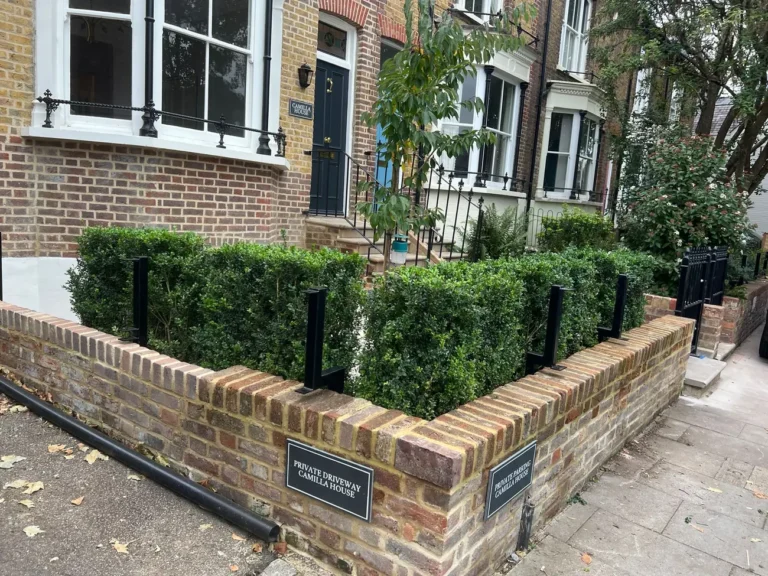 Black metal railings on a brick garden wall at a period property