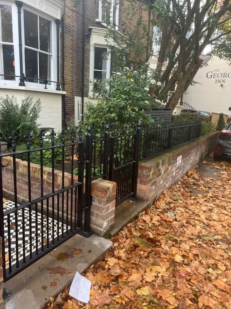 Black railings above a clipped hedge on a period frontage