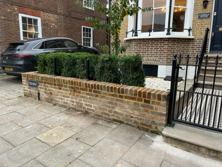 Black metal railings on a low brick garden wall to a period property frontage