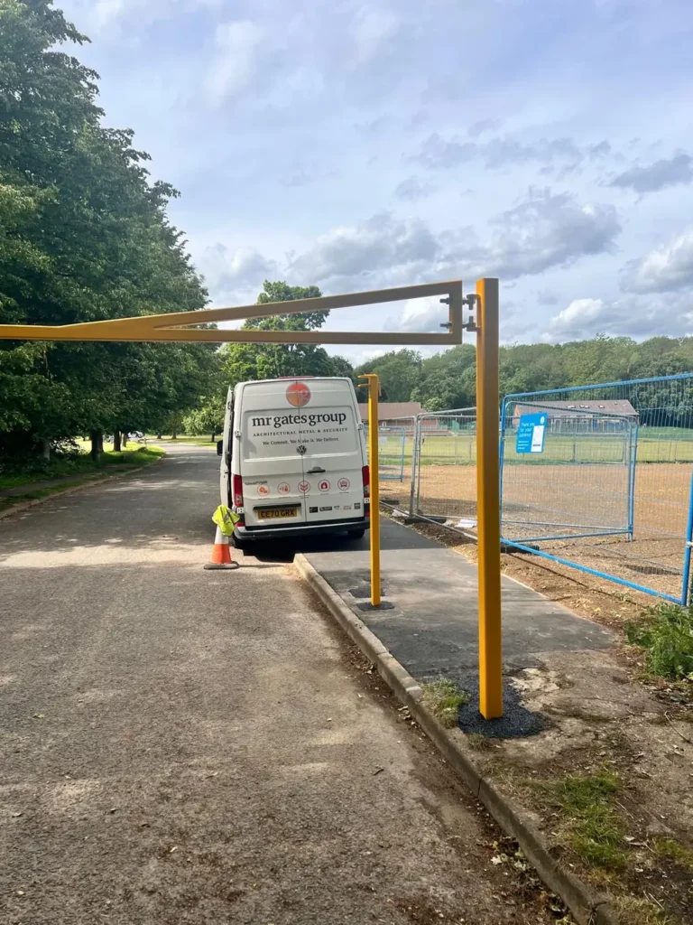 A height restriction barrier and works van at a car park entrance