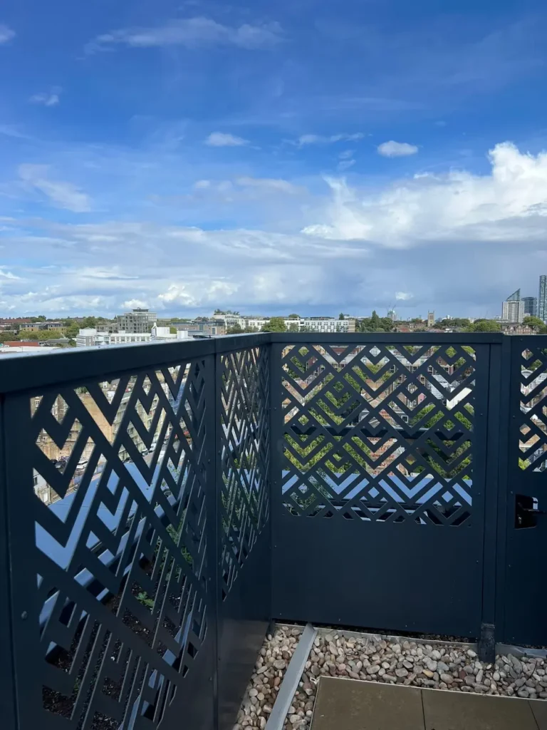Laser-cut decorative screens on a rooftop terrace with a city skyline