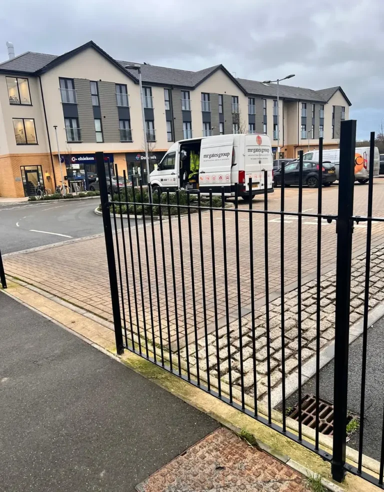 Powder-coated metal driveway gates outside a residential development