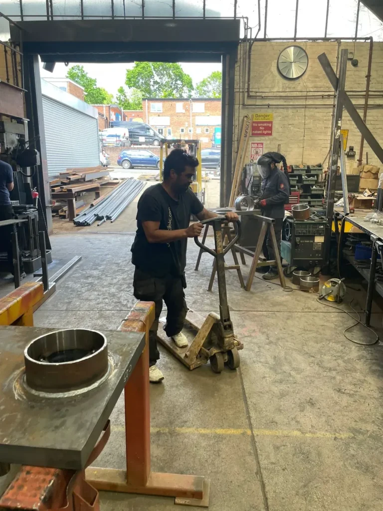 A fabricator working on metalwork at the bench in the Mr Gates workshop