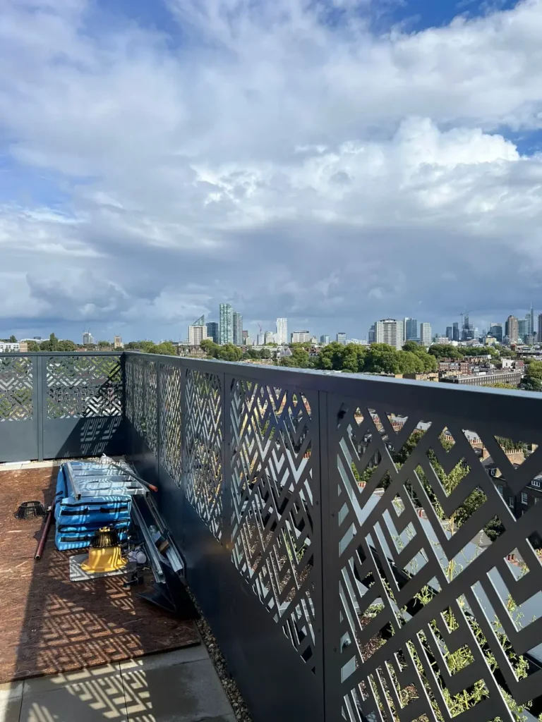 Patterned metal privacy screens around a rooftop terrace