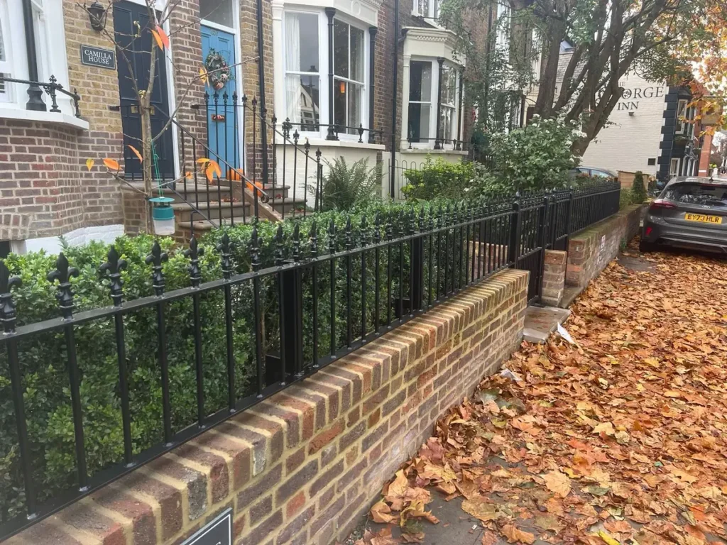 Traditional black metal garden railings on a brick wall outside a period townhouse