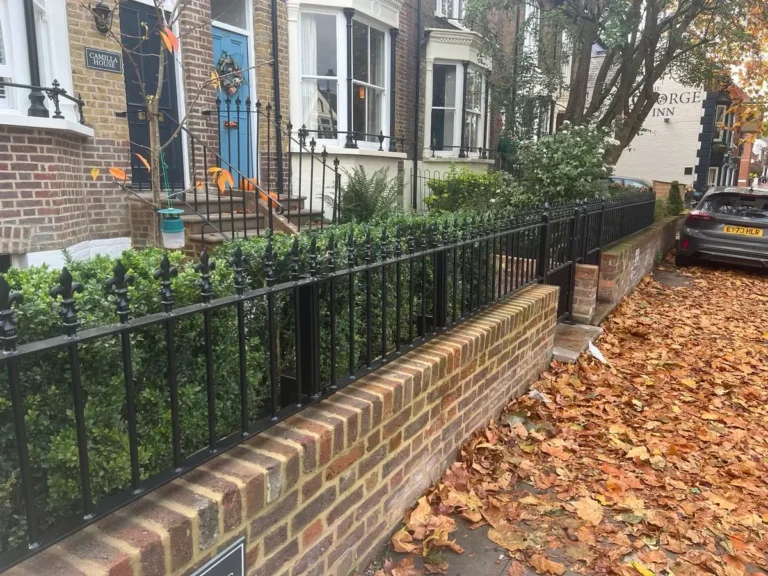 Traditional black metal garden railings on a brick wall outside a period townhouse