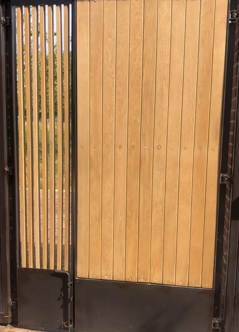 Timber double gates with a slatted top panel in a brick entrance