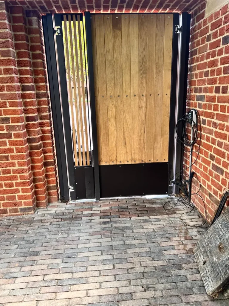 A timber gate with a magnetic lock in a brick pier