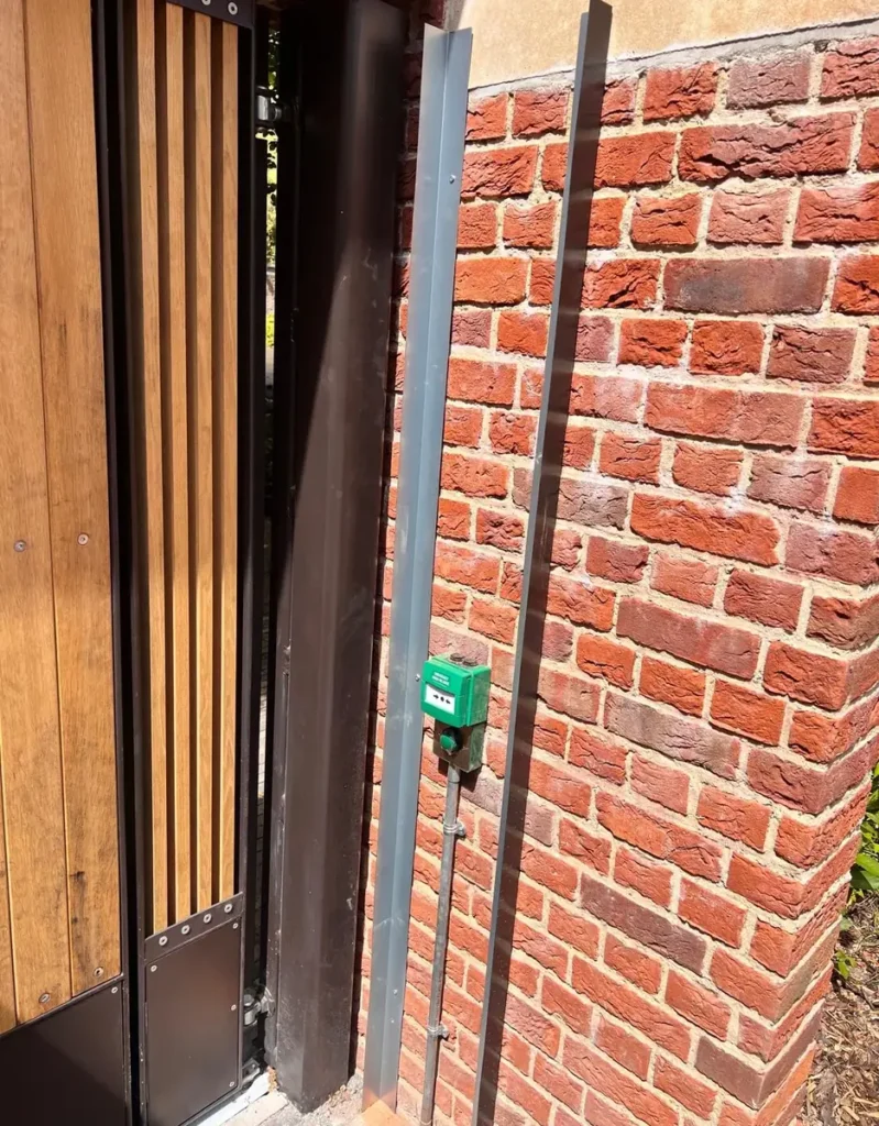 A timber pedestrian gate with keypad entry in a brick surround