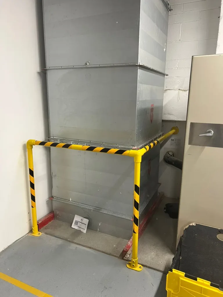 A yellow and black corner guard barrier inside a building