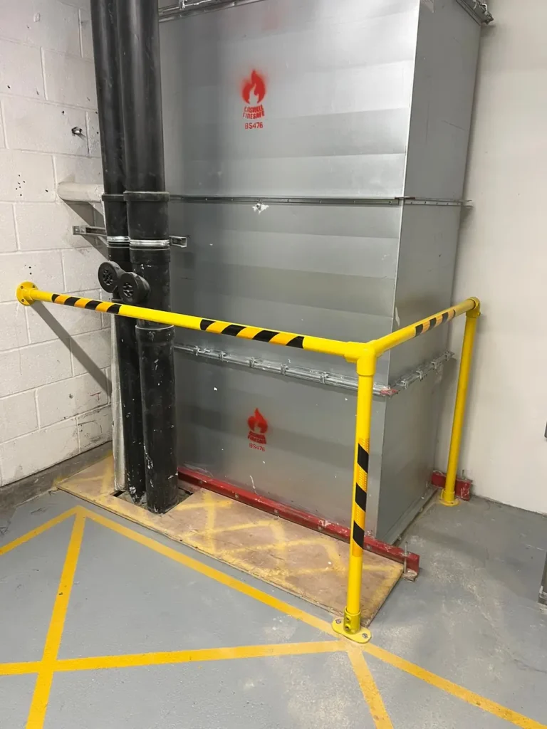 A yellow and black safety barrier protecting a loading bay