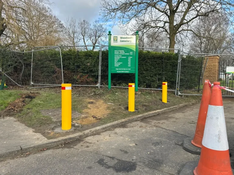 Yellow bollards protecting a grass verge at a site entrance
