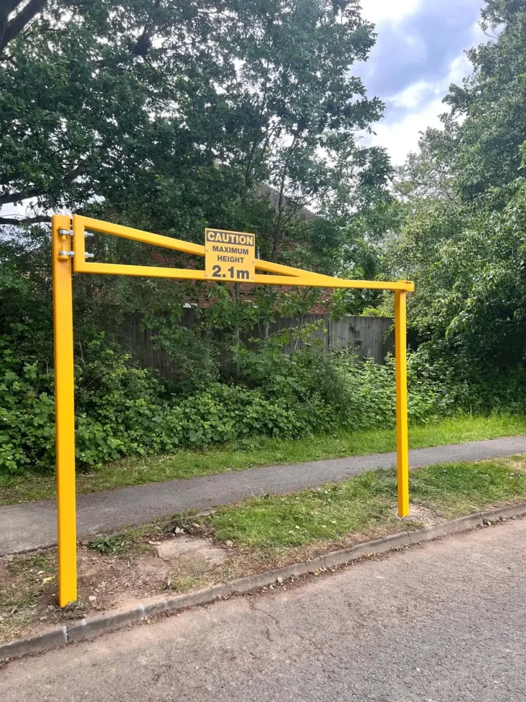 A yellow height restriction barrier at a roadside entrance