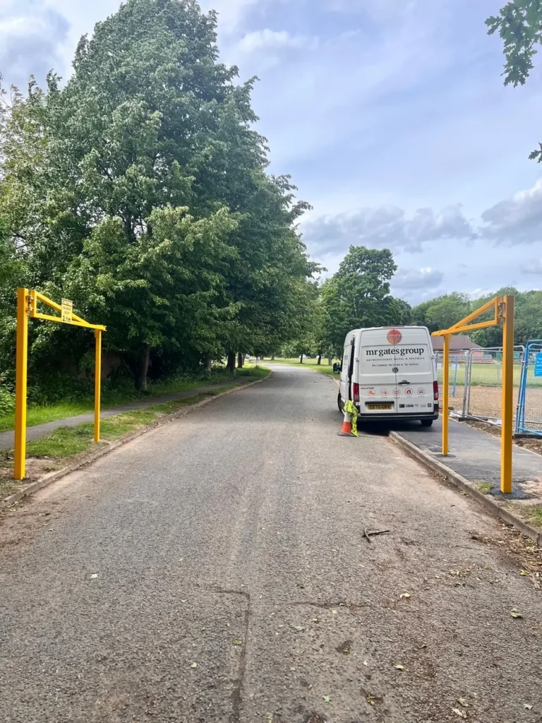 A yellow height restriction barrier with a works van at the entrance