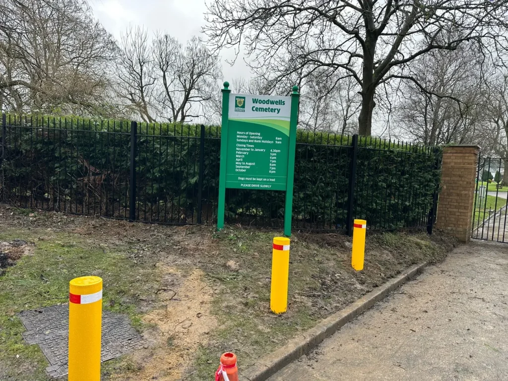 Yellow safety bollards at a cemetery entrance