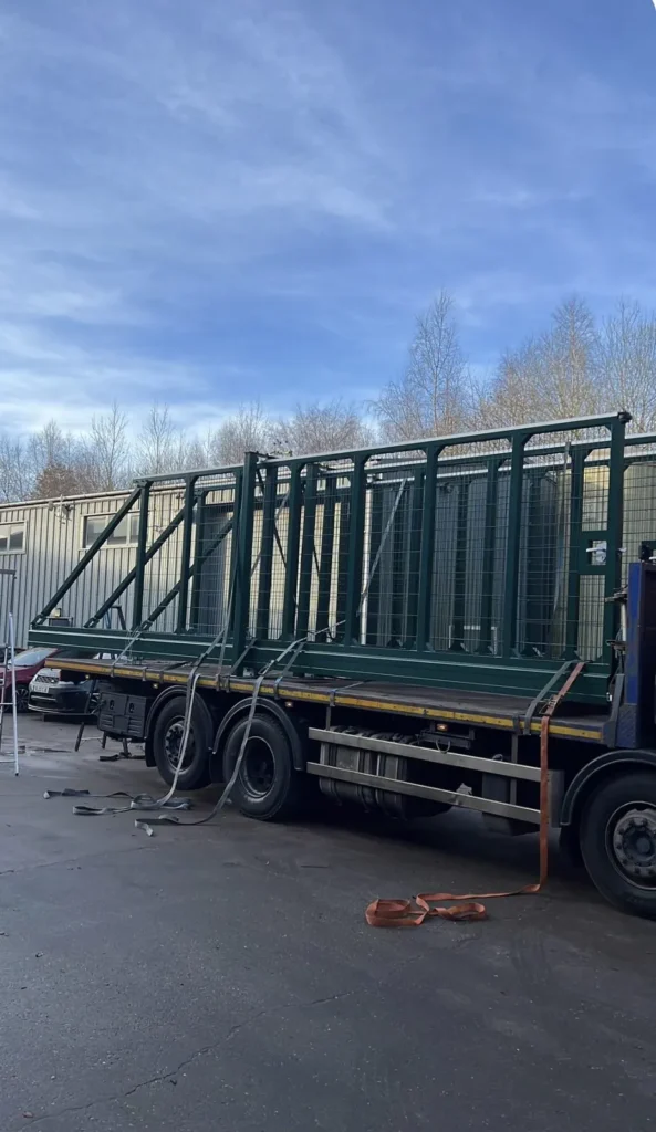 A fully assembled cantilever sliding gate strapped to a crane lorry for delivery