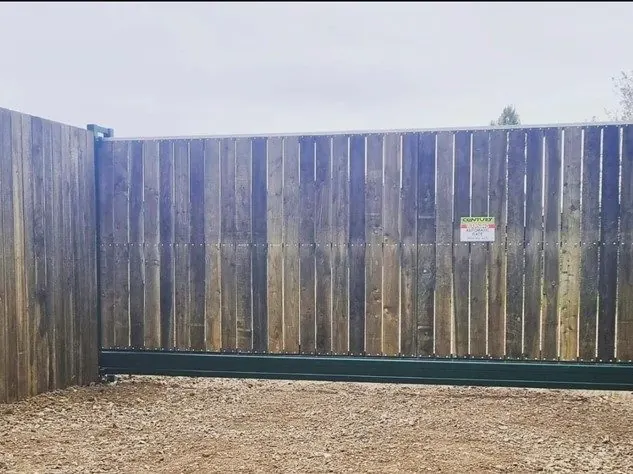 Cantilever sliding gate clad in timber boards to match a timber fence line